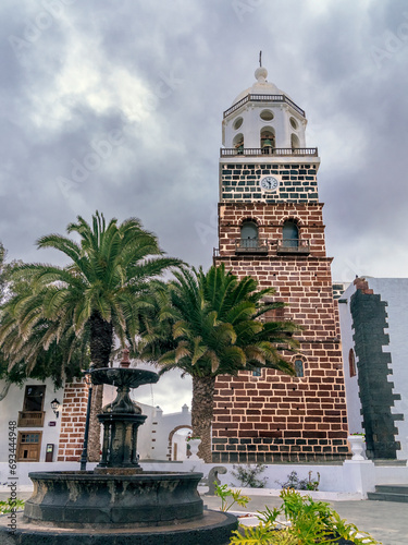 Fountain palmn trees and church in Teguise. Lanzarote. Canary Islands. Spain. Europe. photo