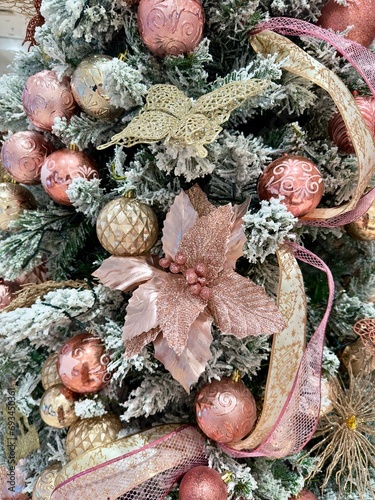 pink rose gold snow christmas tree decorations detail close up with baubles balls and glitter festive ribbon