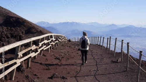 Woman walking in Mount Vesuvius volcano with Pompeii and Italian landscape on the background in Naples, Italy