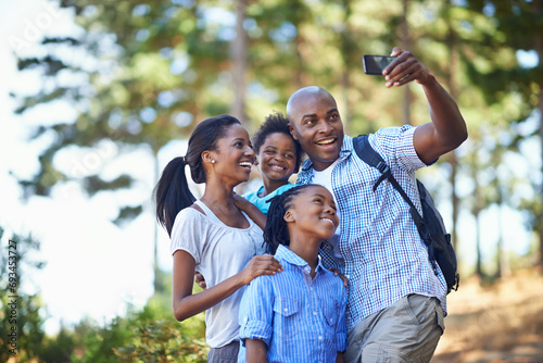 Selfie, love and a black family hiking in the forest together for travel, freedom or summer vacation. Nature, fitness or wellness with a mother, father and children taking a photograph in the woods