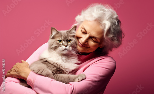 portrait of senior cheerful old woman sitting and hugging her cat isolated on pink background, Generated AI photo