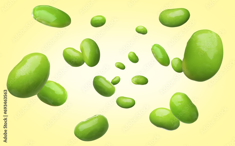 Delicious edamame soybeans falling on light yellow background Delicious edamame soybeans falling on light yellow background
