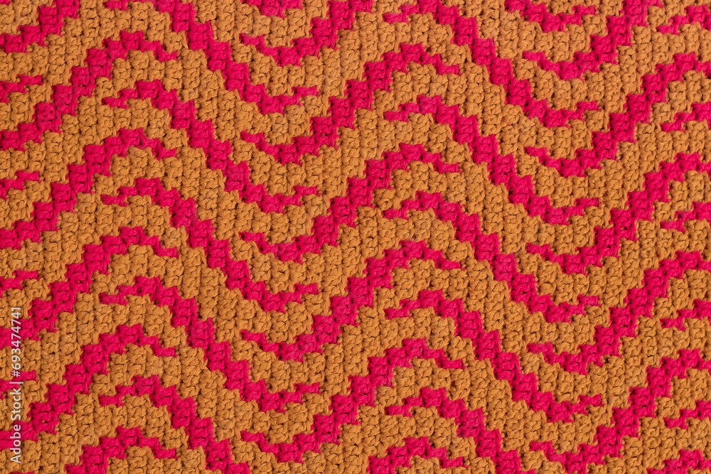 Yellow pink crochet mosaic fabric with abstract pattern. Knitted background. Yellow pink crochet mosaic fabric with abstract pattern. Knitted background.