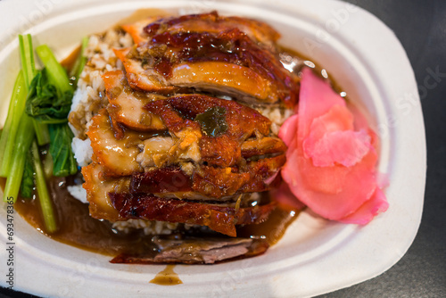 Roasted bbq duck with gravy sauce on top of rice. Top view