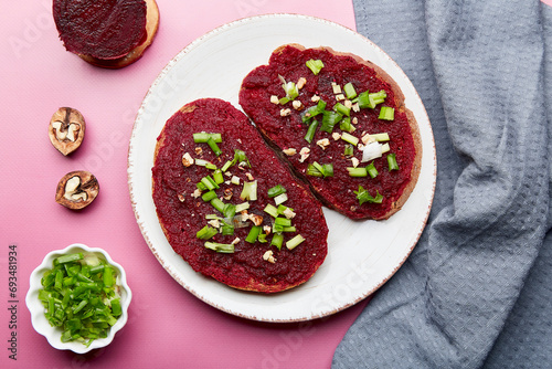 Beetroot spread sandwiches with spring young onion, garlic and walnuts. Vegan healthy spring food. Top view photo