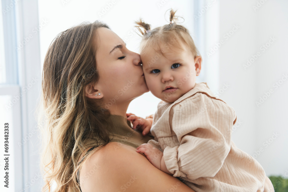 young beautiful mother with a baby girl having great time at home young beautiful mother with a baby girl having great time at home