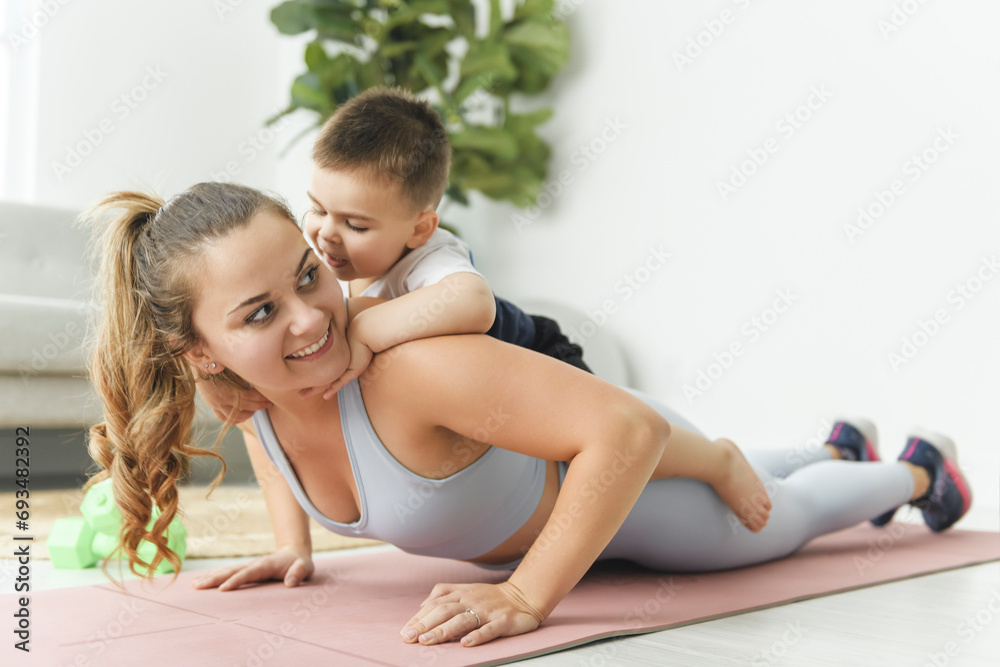 Sport Activities With Baby. Young Mom Exercising With Her Infant Son At Home Sport Activities With Baby. Young Mom Exercising With Her Infant Son At Home