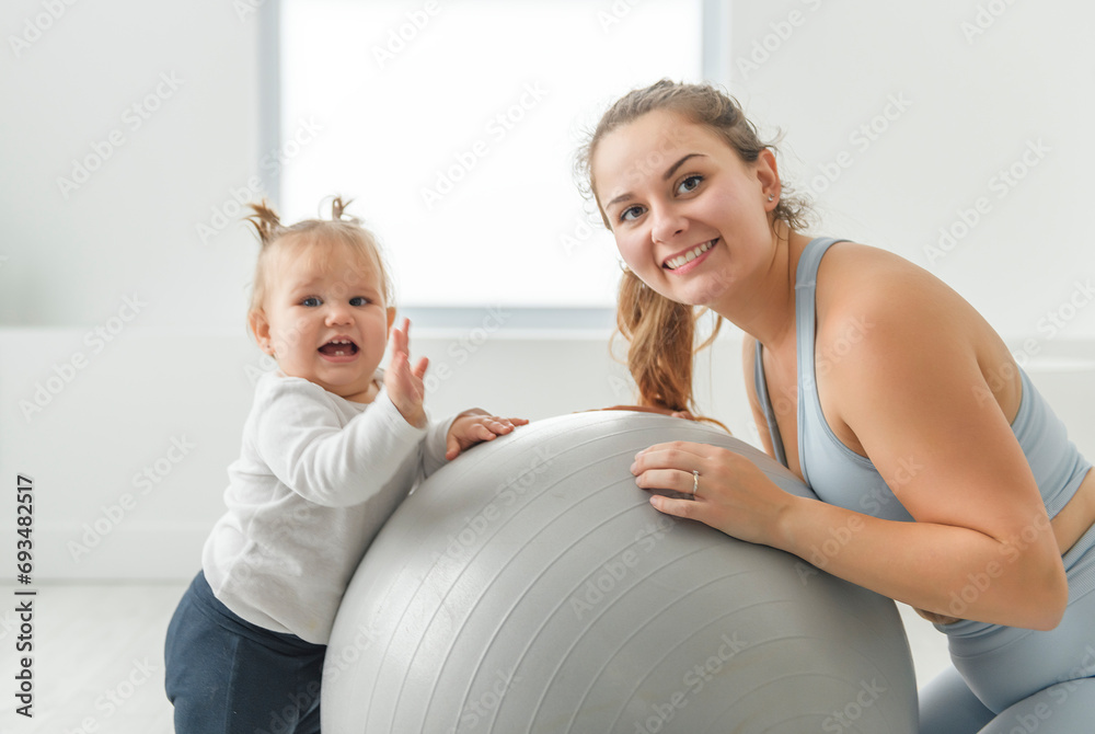 Sport Activities With Baby. Young Mom Exercising With Her Infant Son At Home Sport Activities With Baby. Young Mom Exercising With Her Infant Son At Home