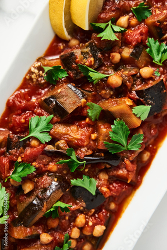 Maghmour or Lebanese moussaka. Dish made from baked or fried eggplant with spices, chickpeas and tomato sauce. Eggplants are stewed in tomato sauce photo