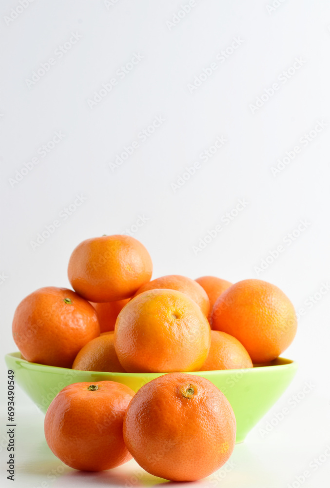 Close up, tangerines on white background and green porcelain plate. Close up, tangerines on white background and green porcelain plate.