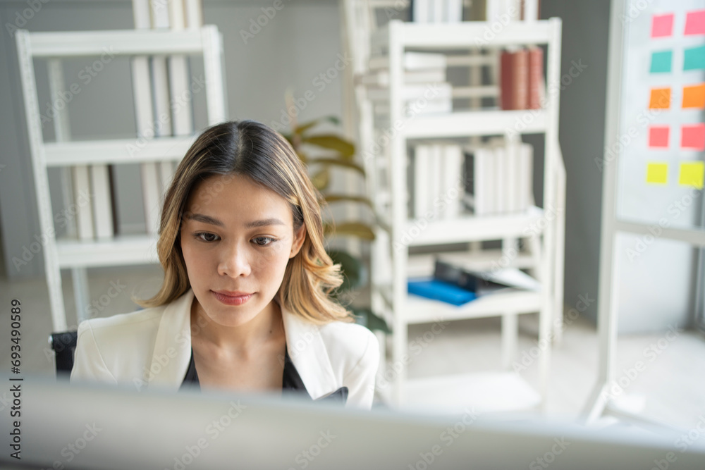 A determined young woman fuels business growth with focused determination in the office. A determined young woman fuels business growth with focused determination in the office.