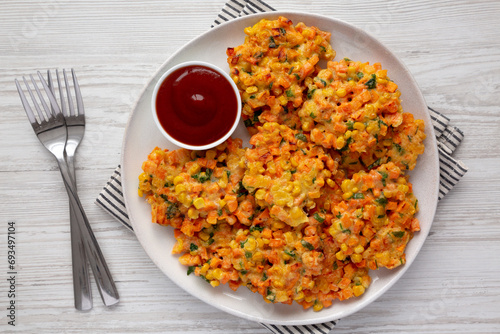 Homemade Carrot Corn Fritters with Ketchup on a Plate, top view. Flat lay, overhead, from above.