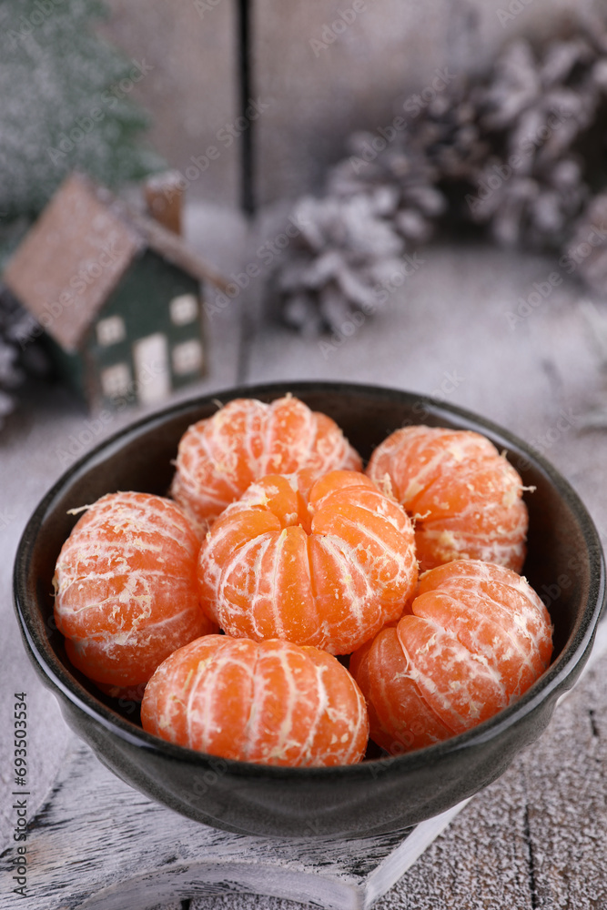 Peeled tangerines in a green bowl on a winter background Peeled tangerines in a green bowl on a winter background