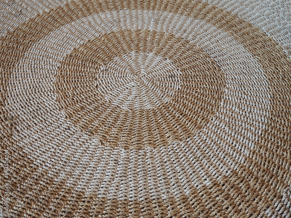 Naklejka premium Circle shaped rugs are woven from jute or natural fibers. Large handmade floor rugs are woven from white and brown rope. Bent jute rope rug
