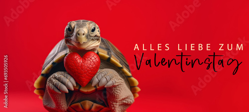 Alles Liebe zum Valentinstag, Grußkarte mit deutschem Text - Niedliche Schildkröte hält rotes Herz , isoliert auf rotem Hintergrund © Corri Seizinger