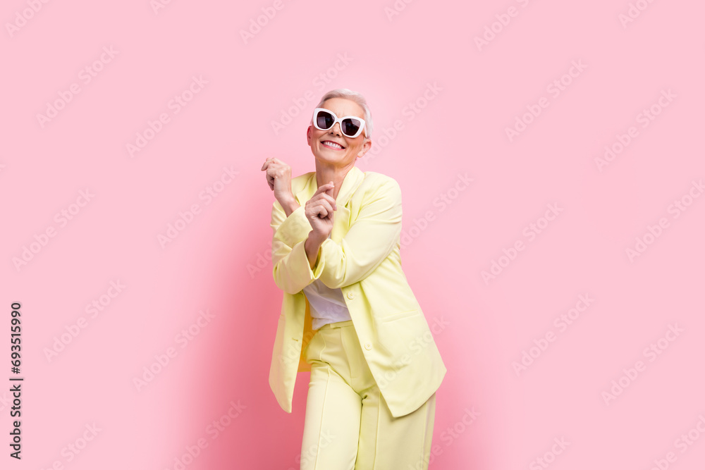 Photo businesswoman in yellow suit dancing after conference where she has promoted to team lead position isolated on pink color background