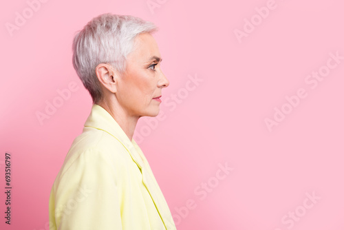 Side profile photo of confident serious mature woman white short haircut looking empty space ad isolated over pink color background