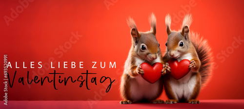 Alles Liebe zum Valentinstag, Grußkarte mit deutschem Text - Niedliches Eichhörnchen Päärchen hält rotes Herz , isoliert auf rotem Hintergrund © Corri Seizinger