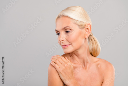 Portrait of dreamy charming lovely woman hand touching naked shoulders after shower gel peeling isolated on gray color background