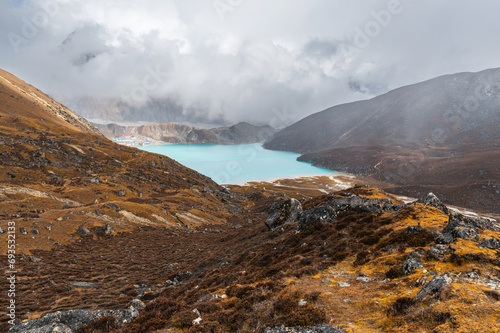 View of Village and Lake Gokyo and Ngozumpa Glacier in clouds during EBC Everest Base Camp trekking or Three Passes Treck. View from Cho La Pass, Solukhumbu, Sagarmatha, Nepal.