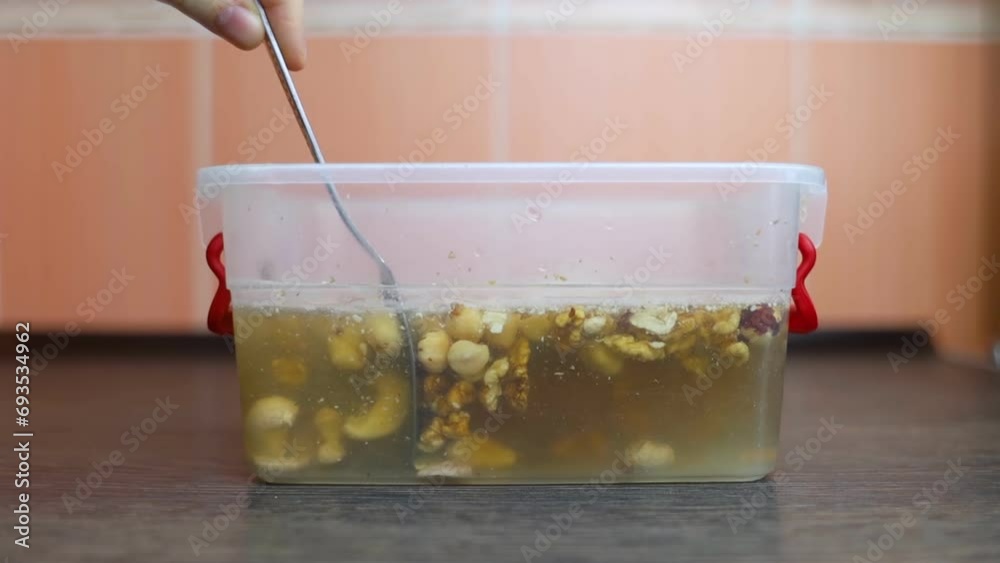 Soaking nuts. Girl shows dirty seeds. Chemical processing of food