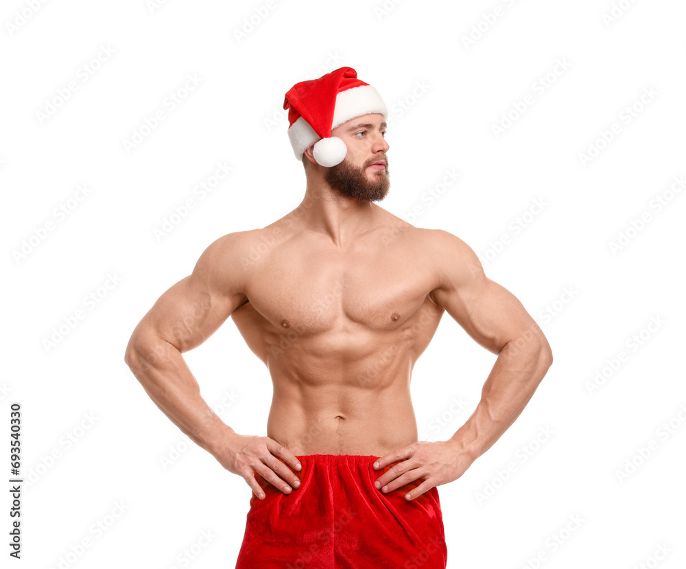Attractive young man with muscular body in Santa hat on white background