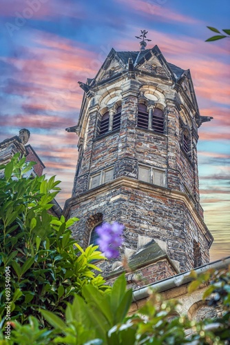 Image of a stone tower of an old castle complex against an evening sky photo