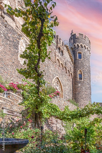 Image of a stone tower of an old castle complex against an evening sky photo