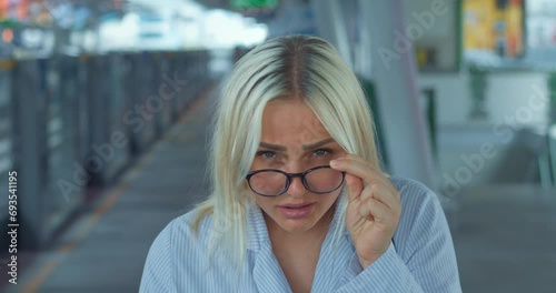 Woman lowers glasses in bewilderment and incomprehension. Expressive reaction to stupidity dullness folly idiocy absurdity delirium. Woman asks again rudely, says what, rolls eyes, shrugs shoulders