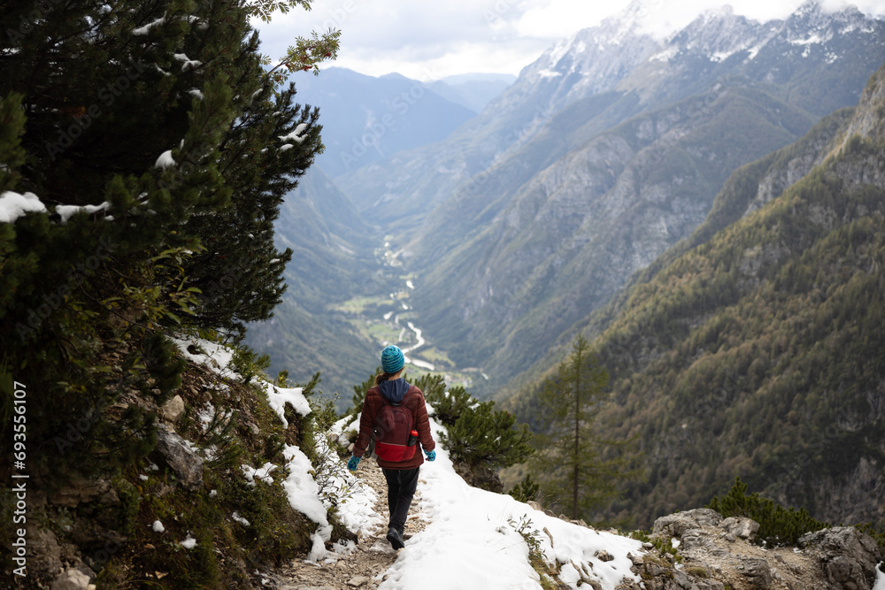 Hiker Returning on a Snowy Footpath to the Valley that is still in Autumn Colors