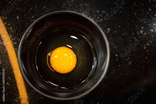Bowl of egg yolk on black bowl from above