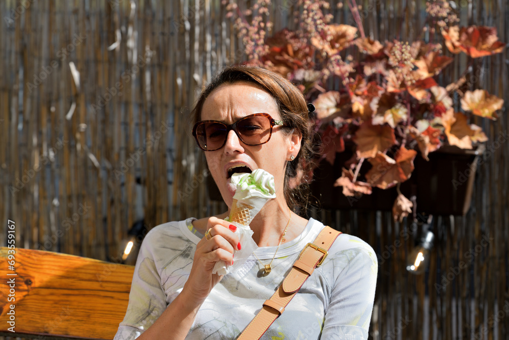 Close-up of a woman's mouth licking sweet ice cream with her tongue