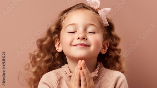 A portrait of a blonde girl is capturing her excitement and hope as she crosses her fingers for good luck, smiles, and closes her eyes, all while praying and pleading for her dream to come