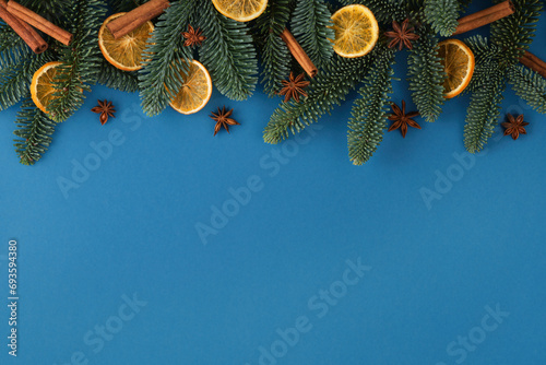 Christmas blue background with fir tree, dried orange, cinnamons and star anise. Top view with copy space for your text photo