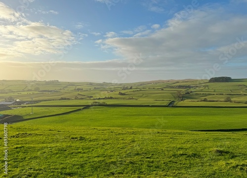 Panoramic, late day winter landscape, with fields, farms, dry stone walls, and hazy clouds, looking from, Bank Lane, Silsden, UK