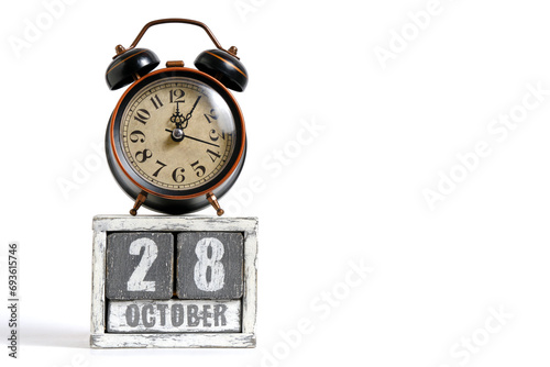 October 28 on wooden calendar with alarm clock white background. photo