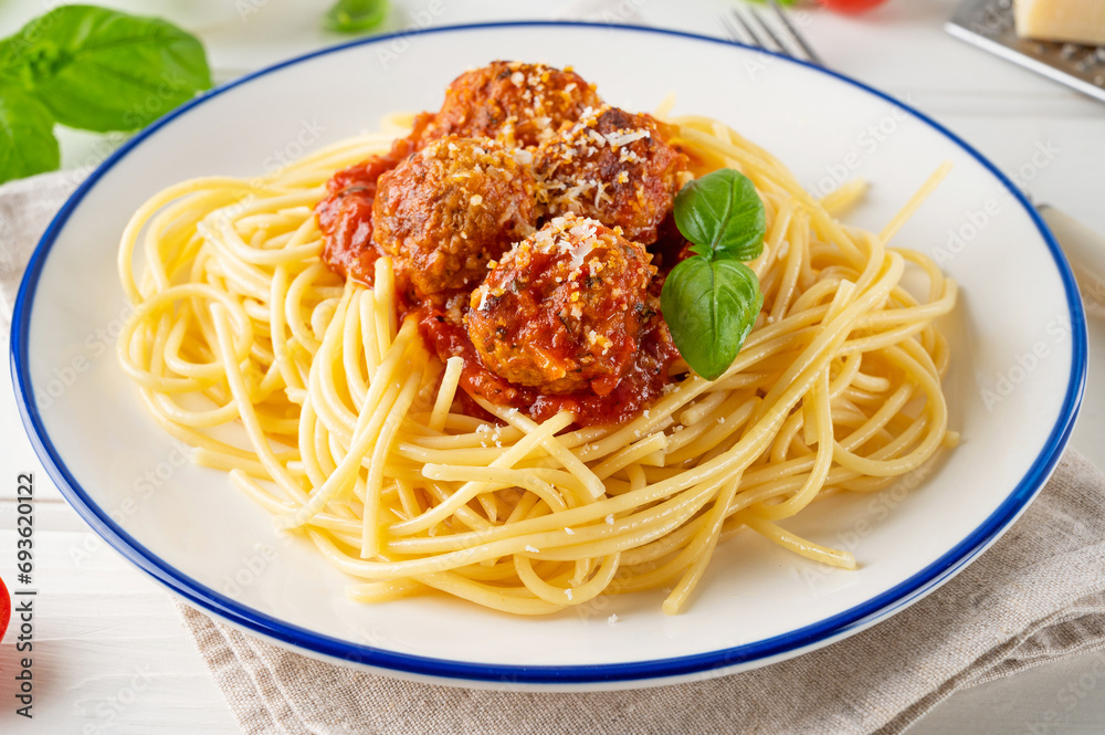 Traditional Italian spaghetti pasta with meatballs, tomato sauce and parmesan cheese, selective focus. Comfort food.