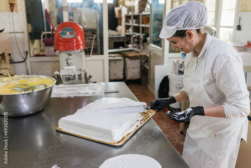 Happy woman preparing cake in bakery photo