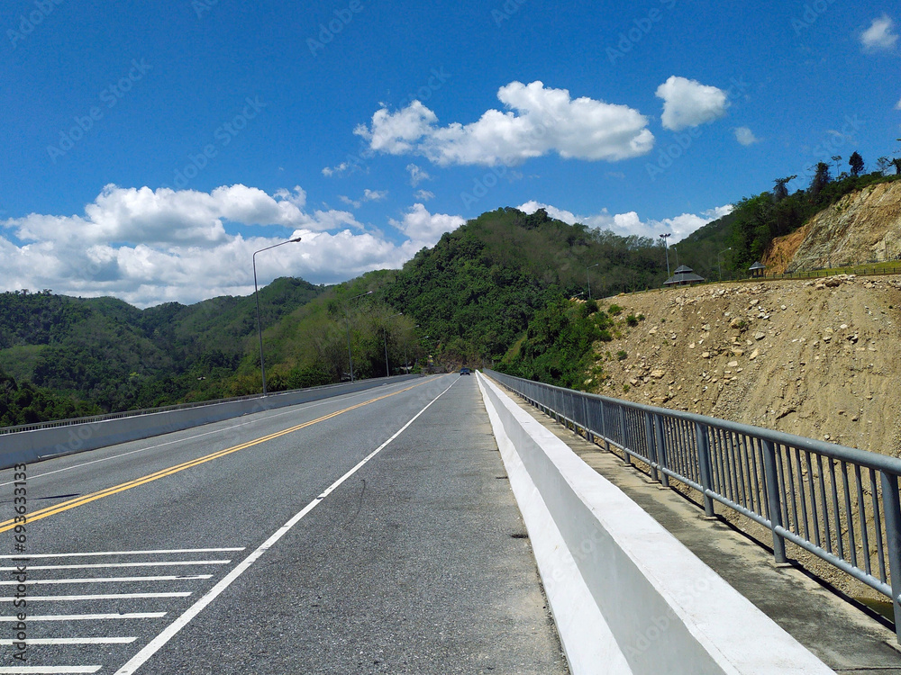 The road on the mountain with blue sky and white clouds background.
