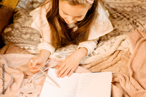 cute beautiful long-haired girl writing a letter to santa claus. New Year's atmosphere, make a wish. the child sits in the car and reads a book......