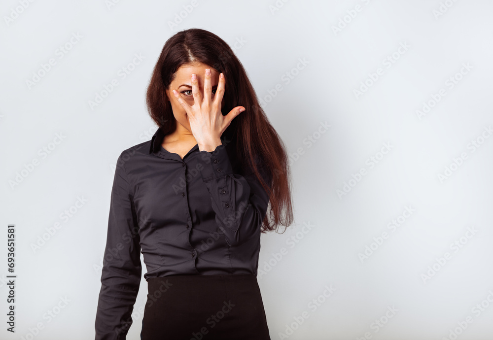 Happy fun business beautiful woman covering and hiding the face the palm in blue shirt on light blue studio background with empty copy space. Closeup Happy fun business beautiful woman covering and hiding the face the palm in blue shirt on light blue studio background with empty copy space. Closeup