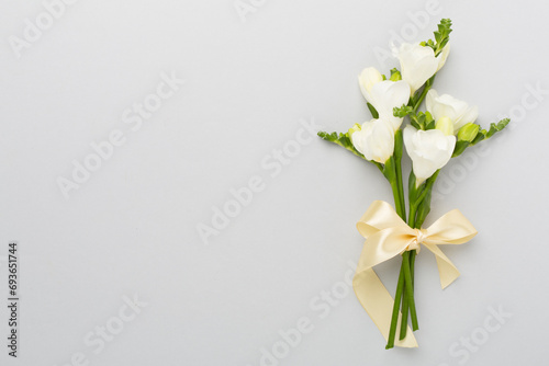 White fresia flower on color background, top view