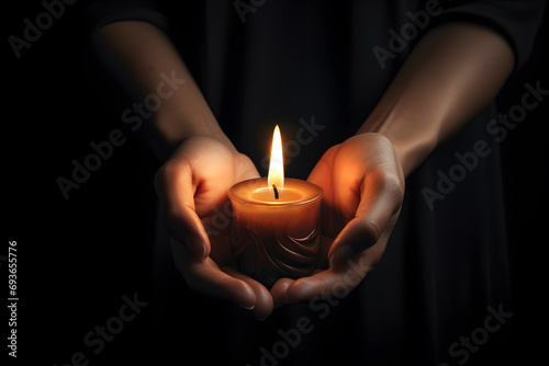 Burning candle in female hands 