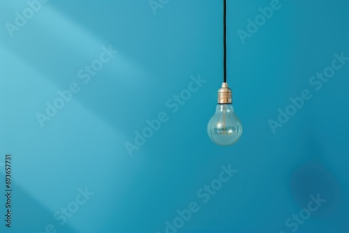 light bulb hangs against a blue backdrop, symbolizing the spark of fresh ideas and innovation