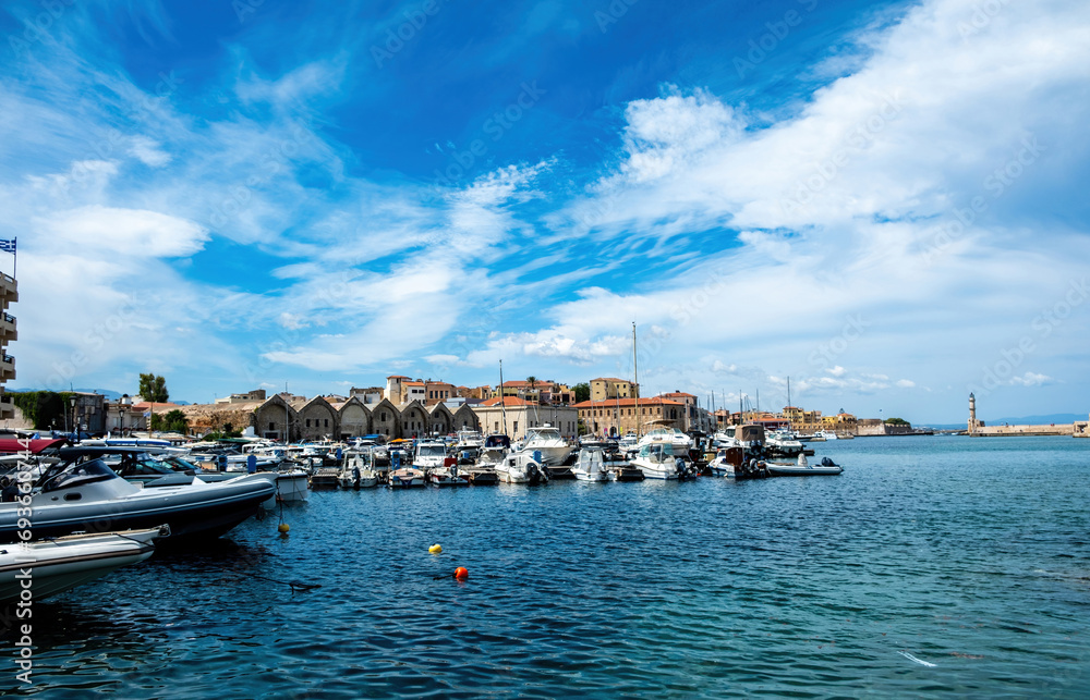 Venetian harbour in Old Town of Chania Crete Greece. Moored boat at marina, beacon, sea, blue sky.