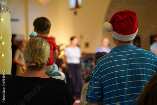 Couple from behind watching the carols church service Christmas time