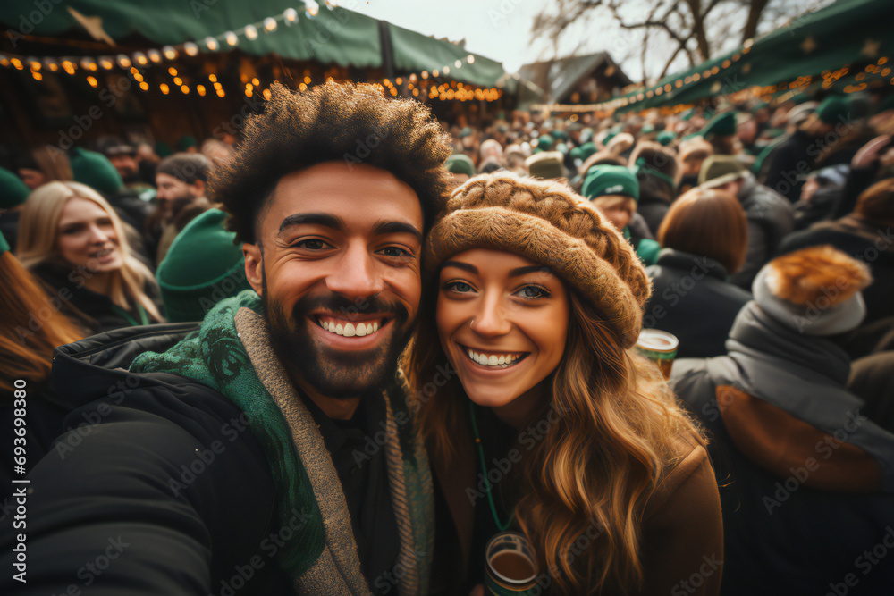 Fototapeta premium Happy people in St Patrick's Day outfits with beer taking selfie in city. St Patrick day. green beer and coins. Glasses of lager beer, a hat and coins with shamrock.