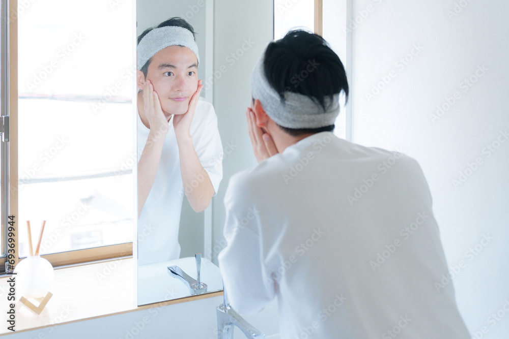 洗面台でスキンケアする若い男性 洗面台でスキンケアする若い男性
