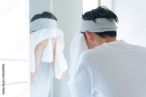 洗顔した顔をタオルで顔を拭く若い男性 photo