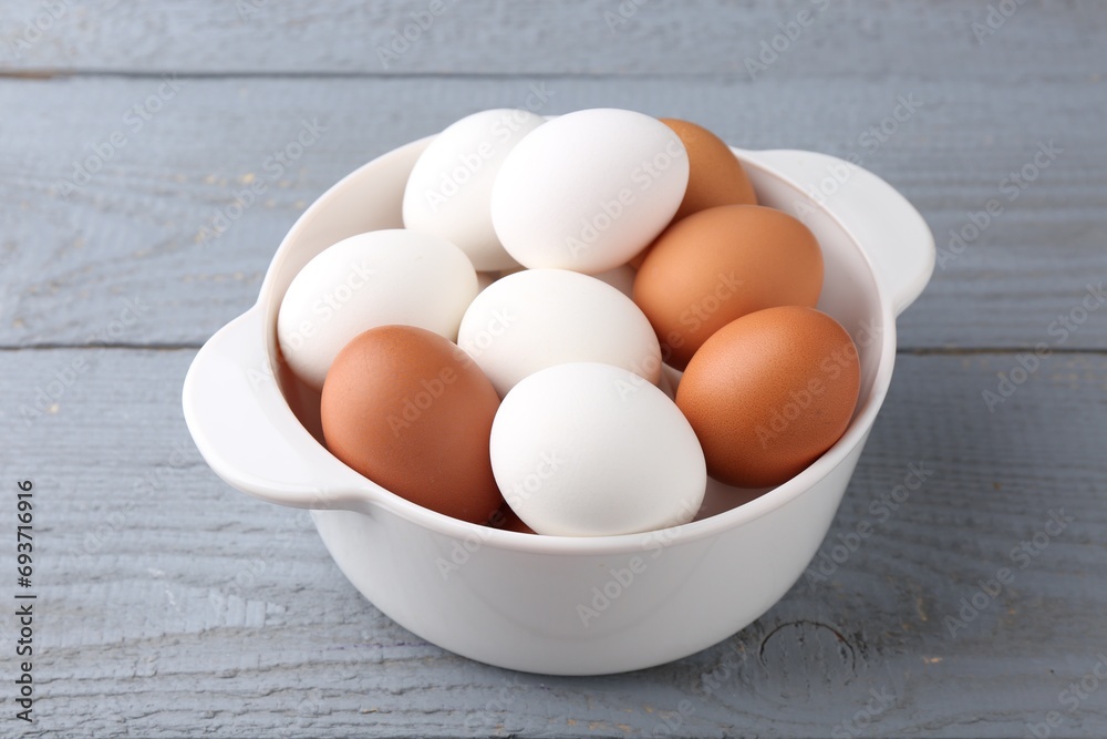 Unpeeled boiled eggs in saucepan on grey wooden table, closeup Unpeeled boiled eggs in saucepan on grey wooden table, closeup